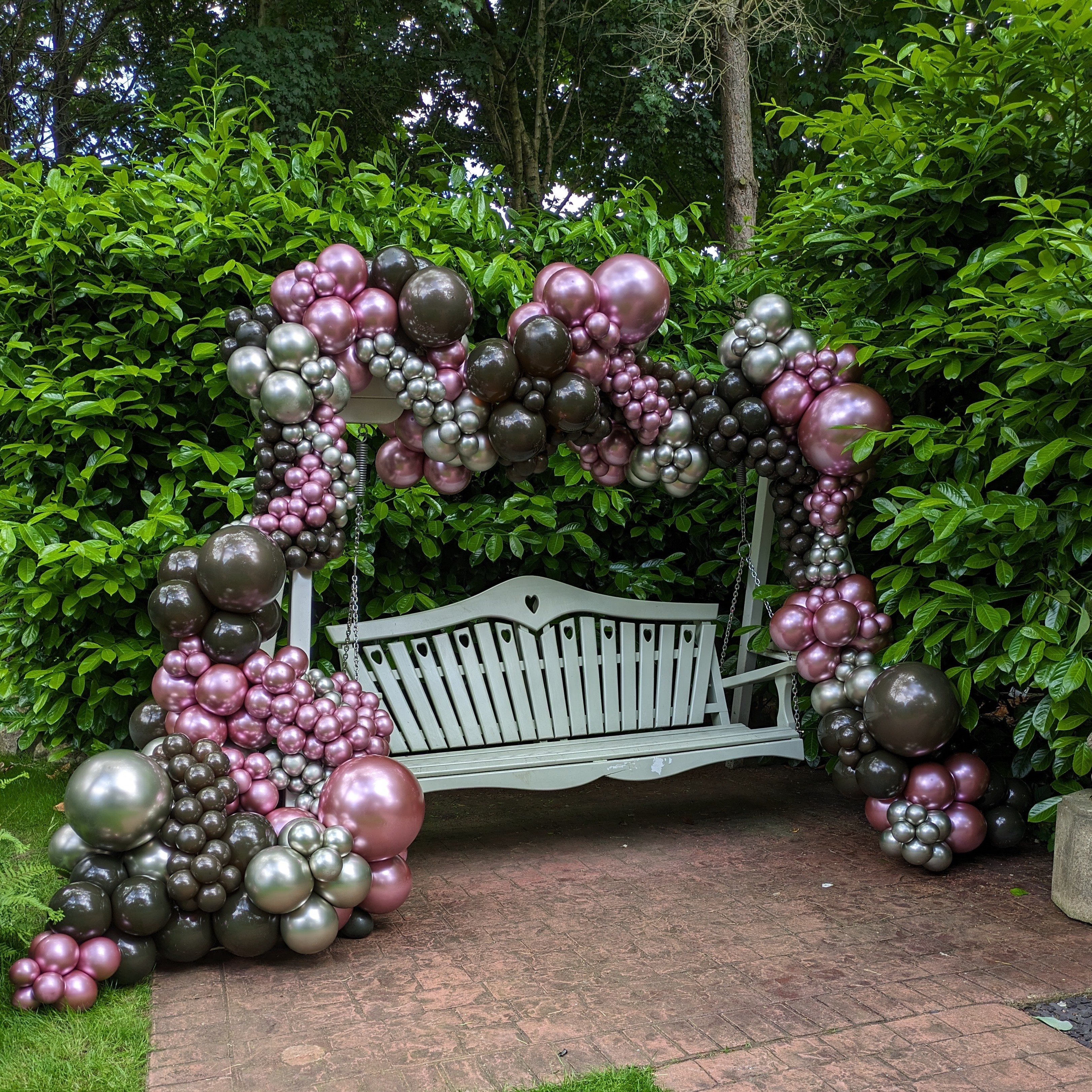 A garden bench surrounded by chrome balloons