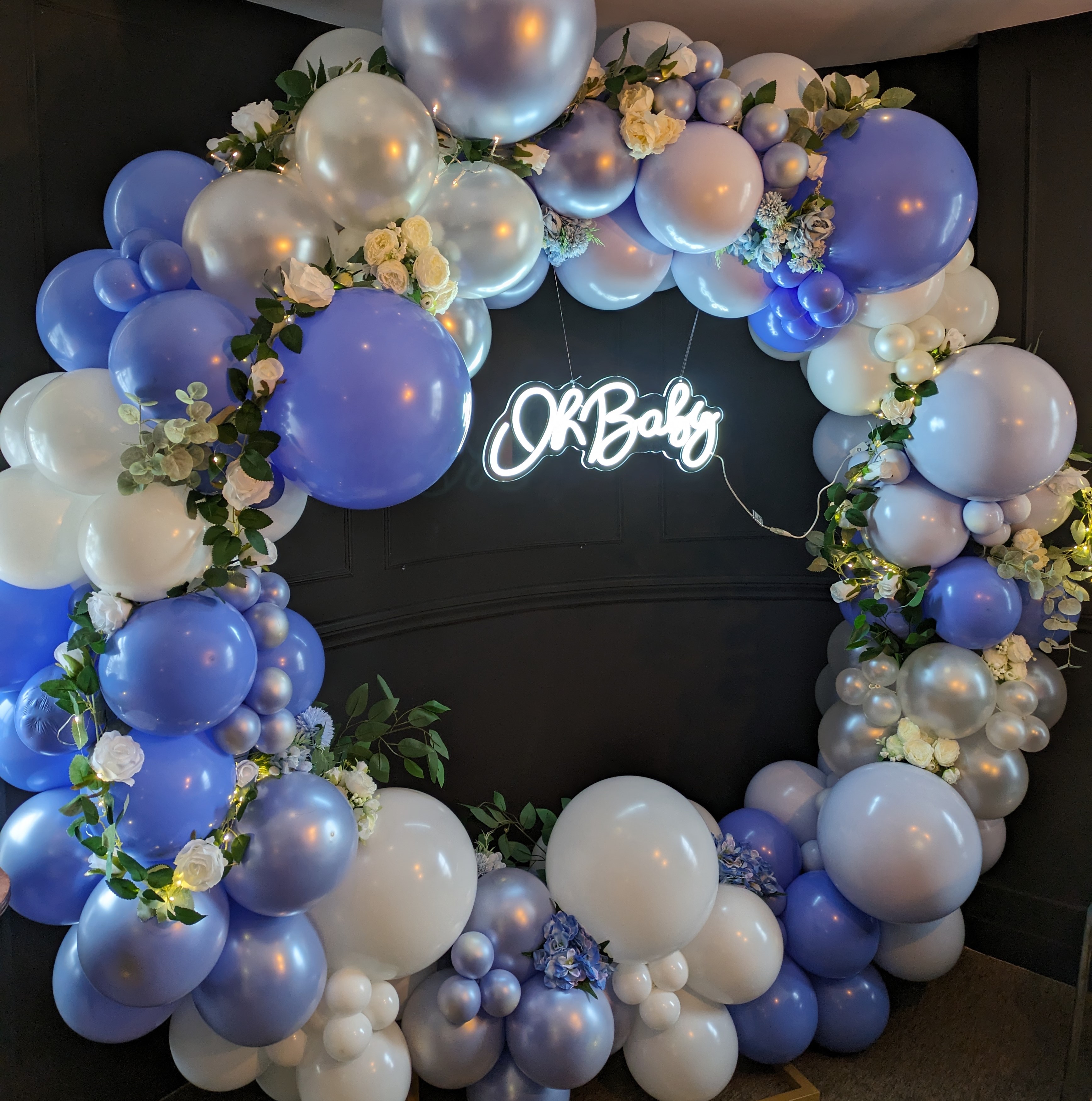 A large balloon ring surrounding a neon sign that says 'Oh Baby'