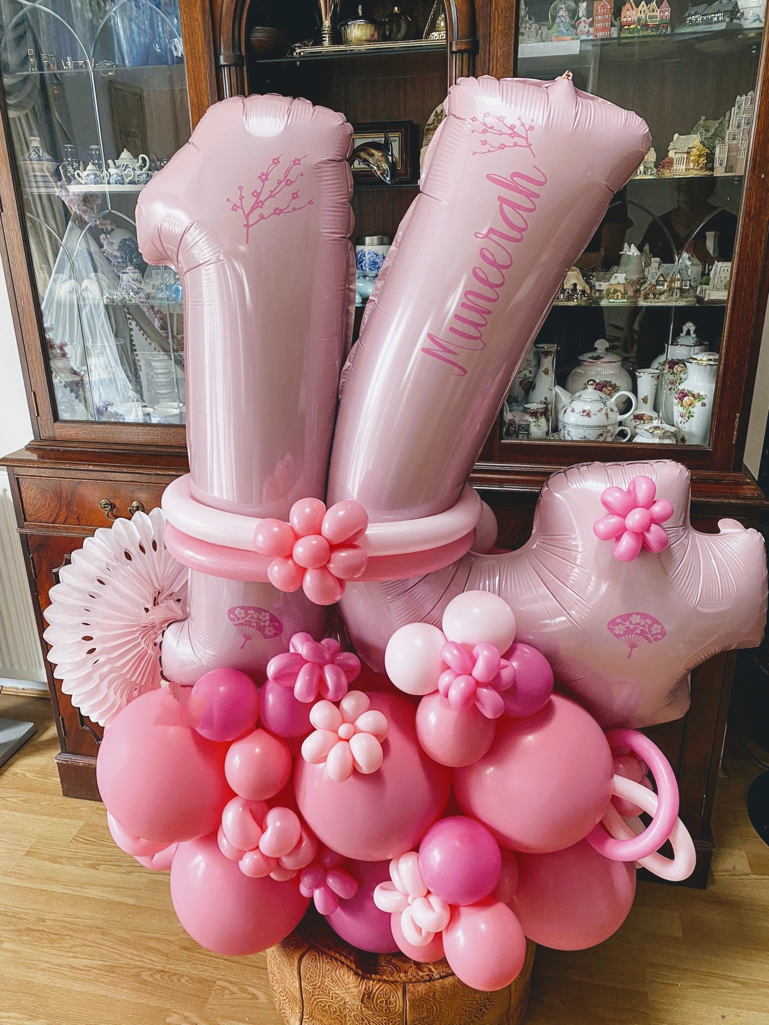 A flowery pink balloon display supports a large number 14 foil balloon