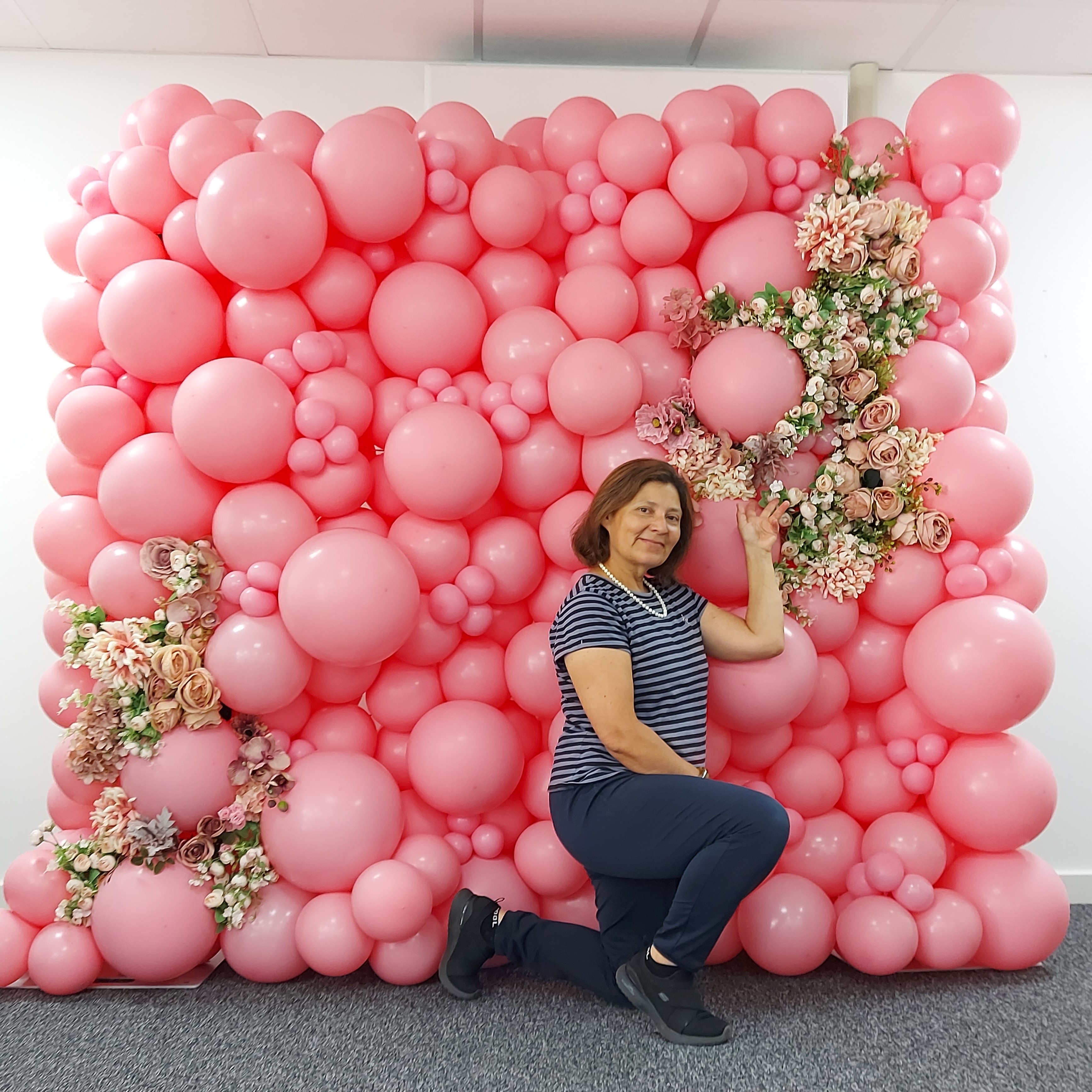 A bubbly pink balloon wall, garnished with flowers